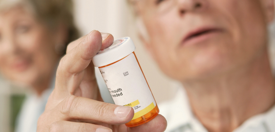 man holding pill bottle | most effective ED medication | Victory Mens Health